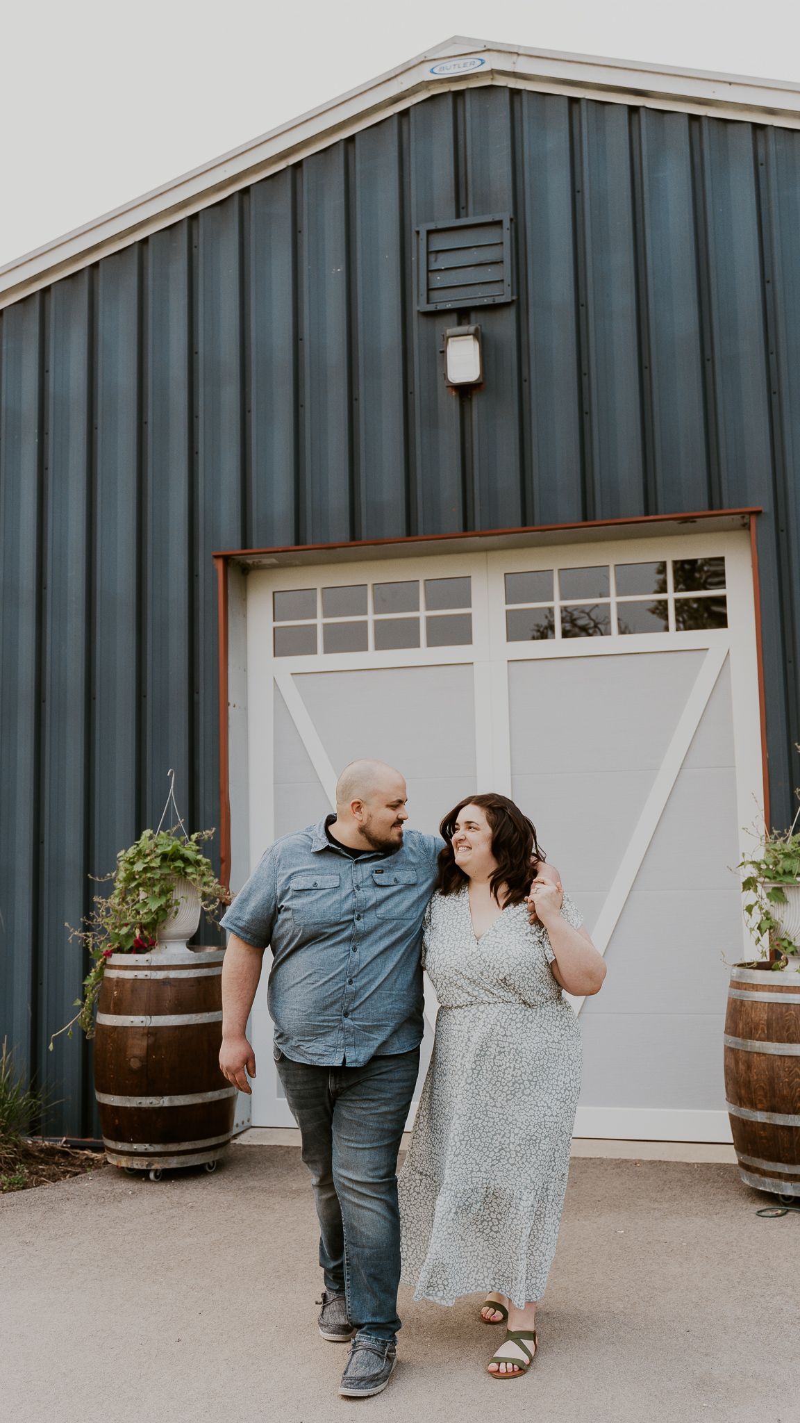 A man and a woman are walking in front of a garage door.