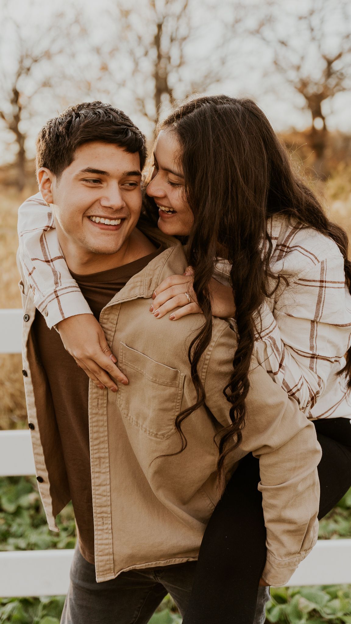 a man is carrying a woman on his back .