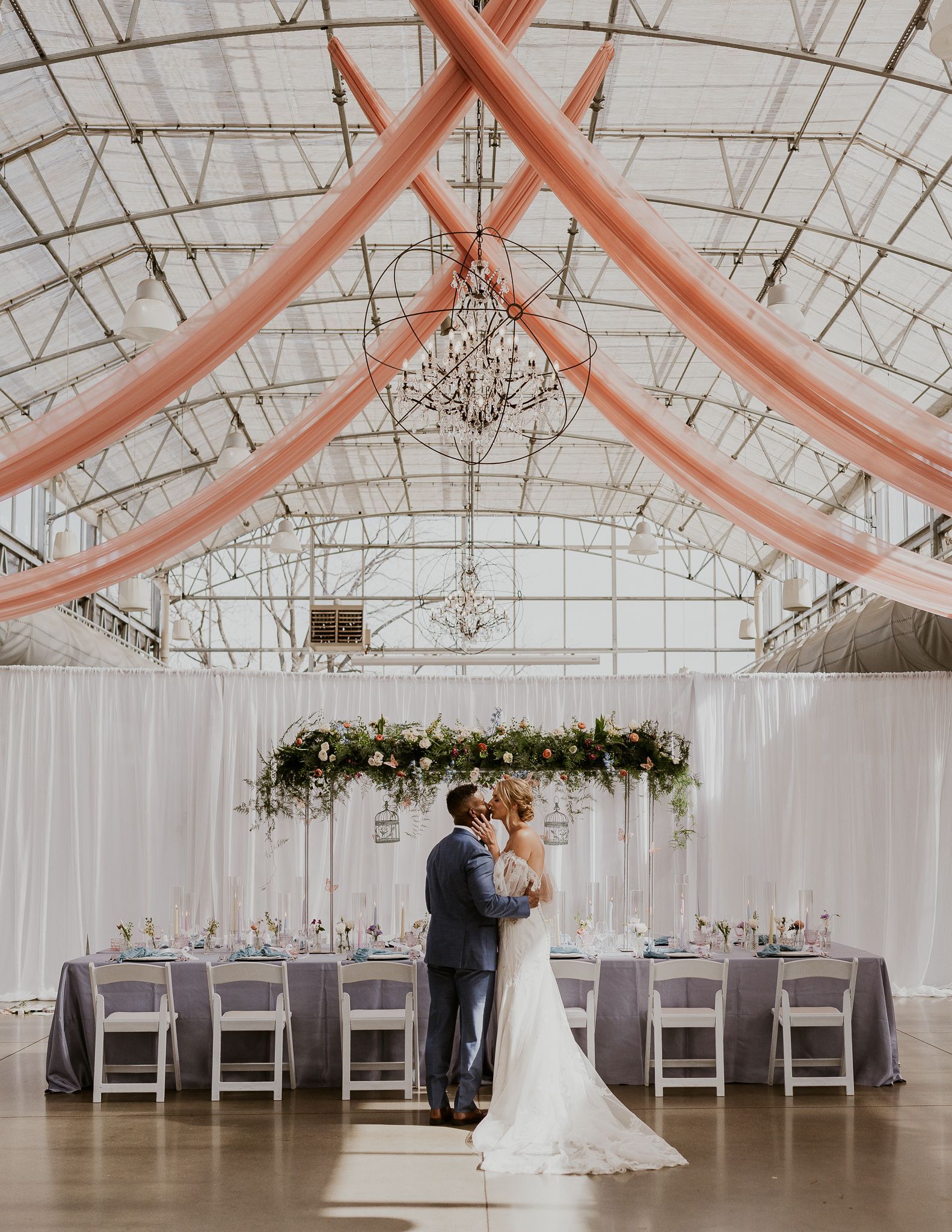 A bride and groom are posing for a picture in front of a tree.