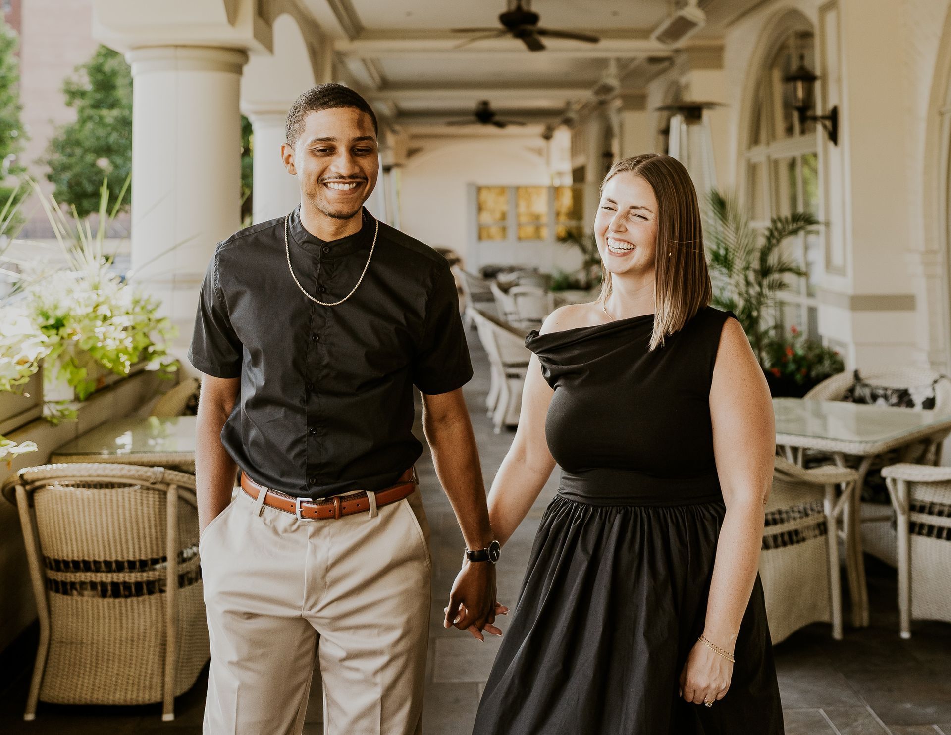 A man and a pregnant woman are standing in a field.