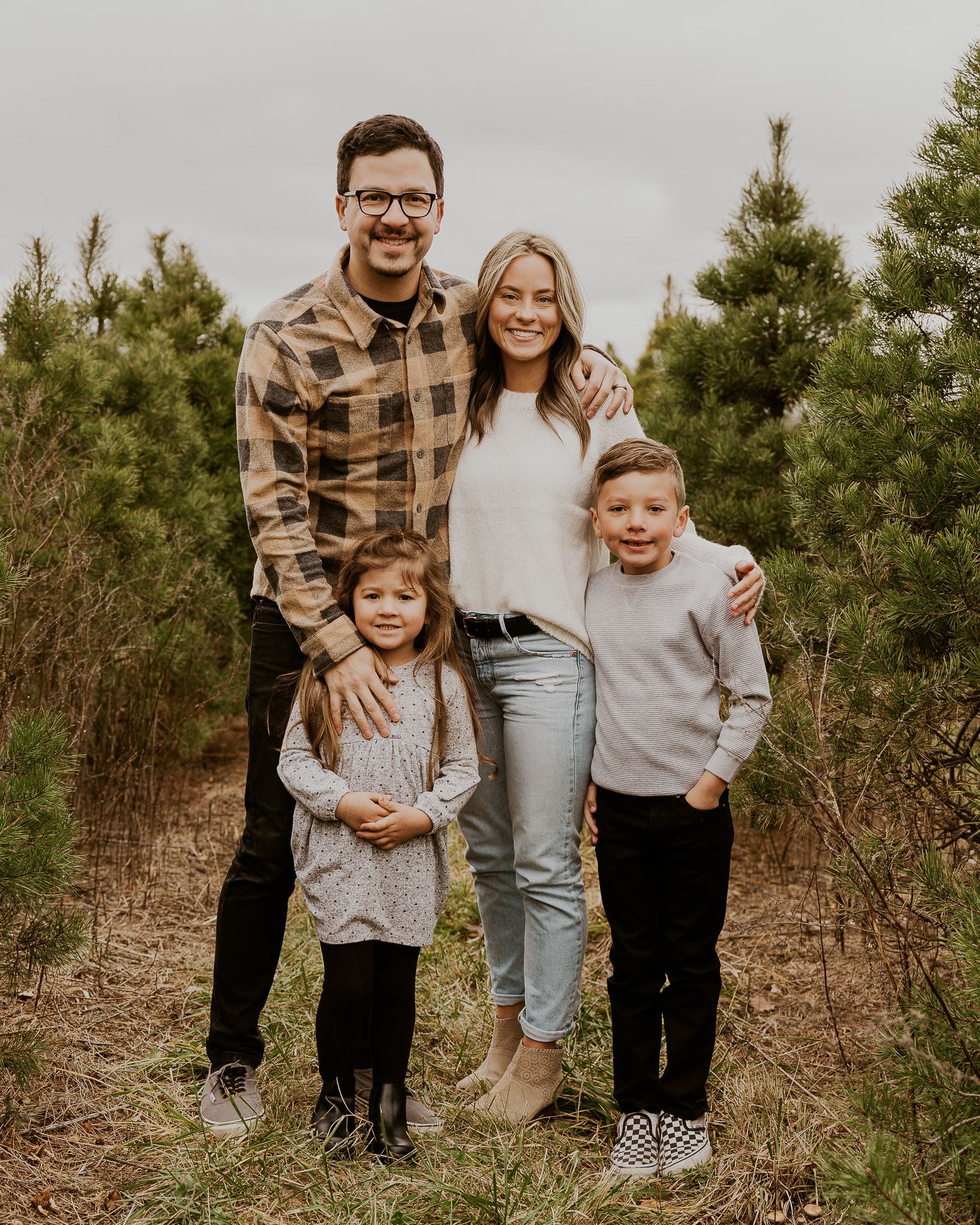 A family is posing for a picture in a field of trees.