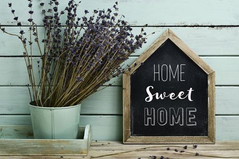 Home Sweet Home sign next to a bucket of lavender on a wood table
