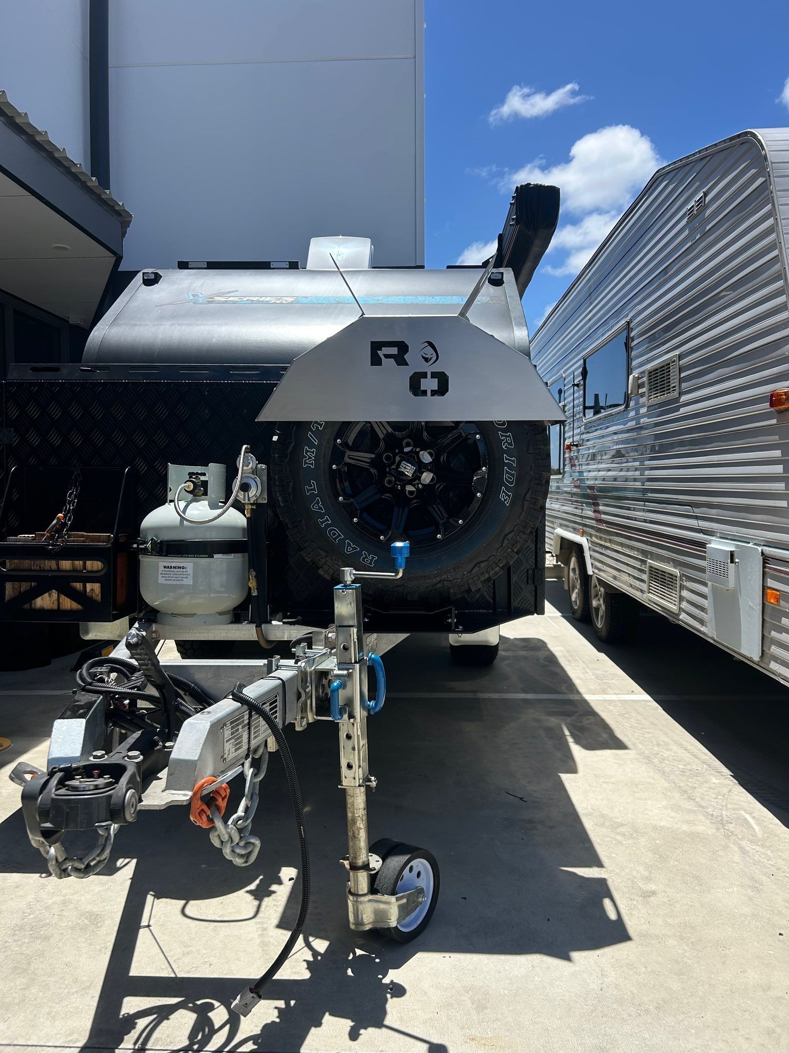 Black Caravan With Spare Tire, Propane Tank — G&S Caravan Services in Taylors Beach, NSW
