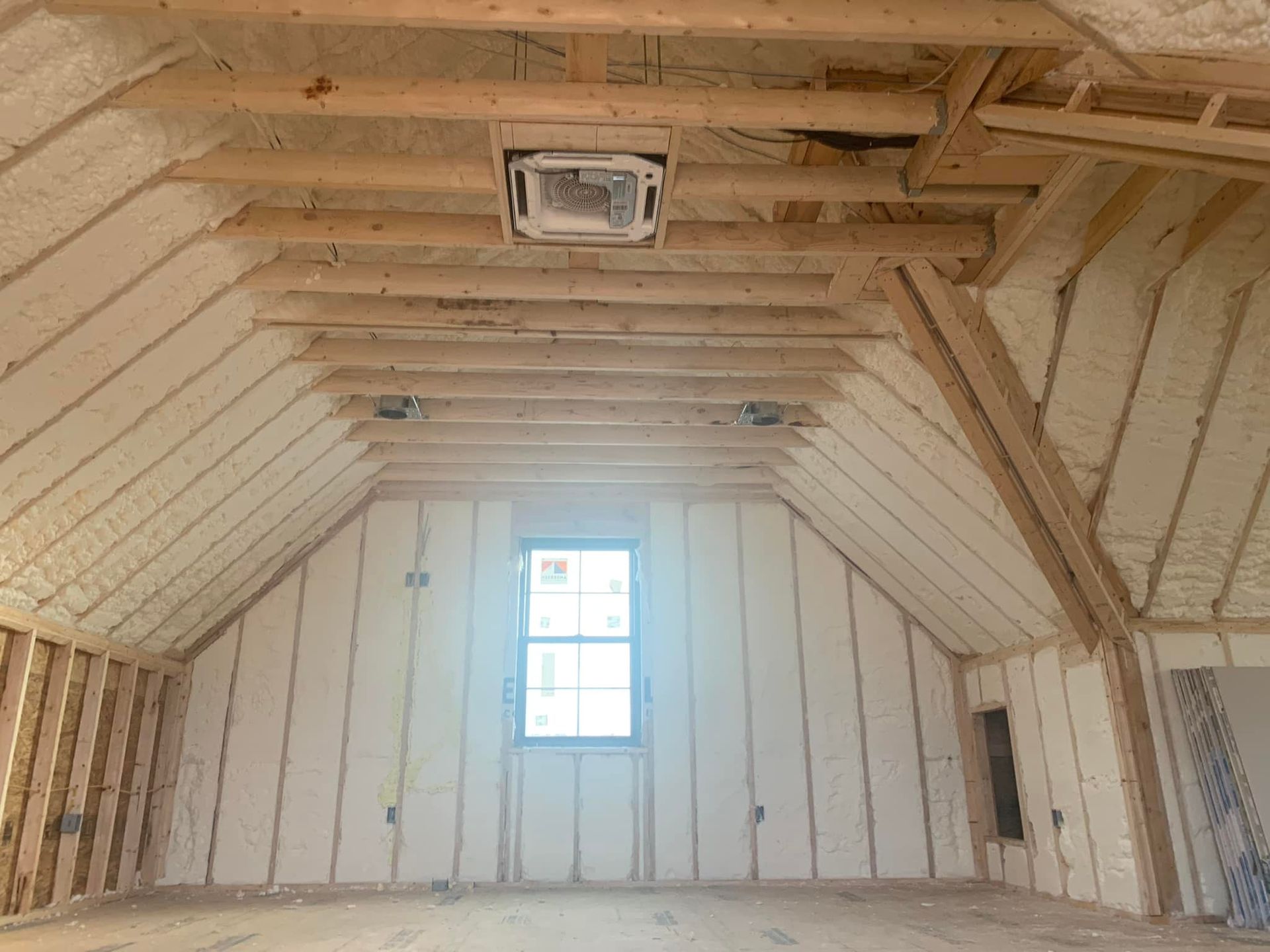 There is a window in the attic of a house being built.