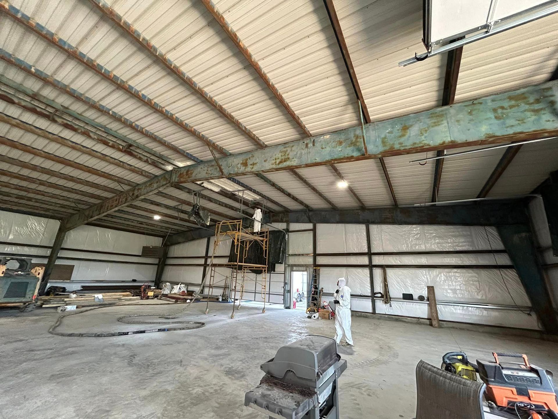 A large warehouse with a roof that is being remodeled.