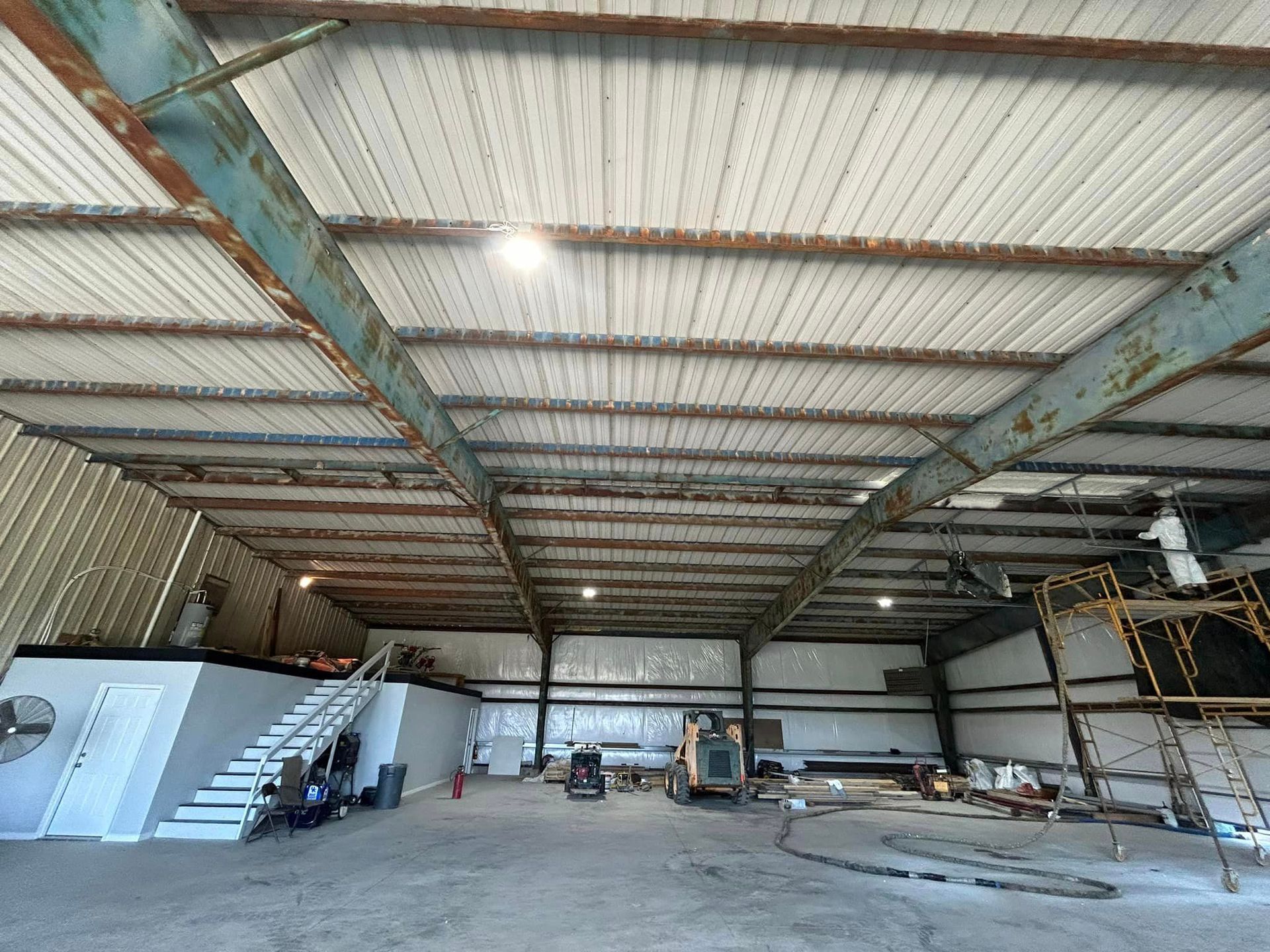 A large warehouse with a staircase leading up to the second floor.