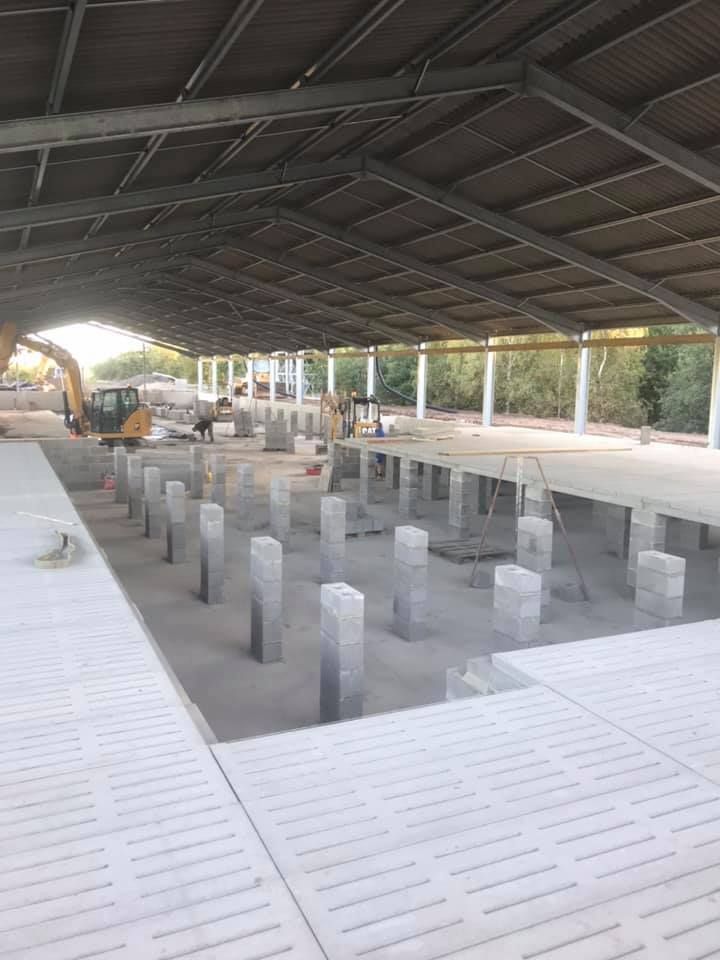 A large building under construction with a roof and a lot of pillars.