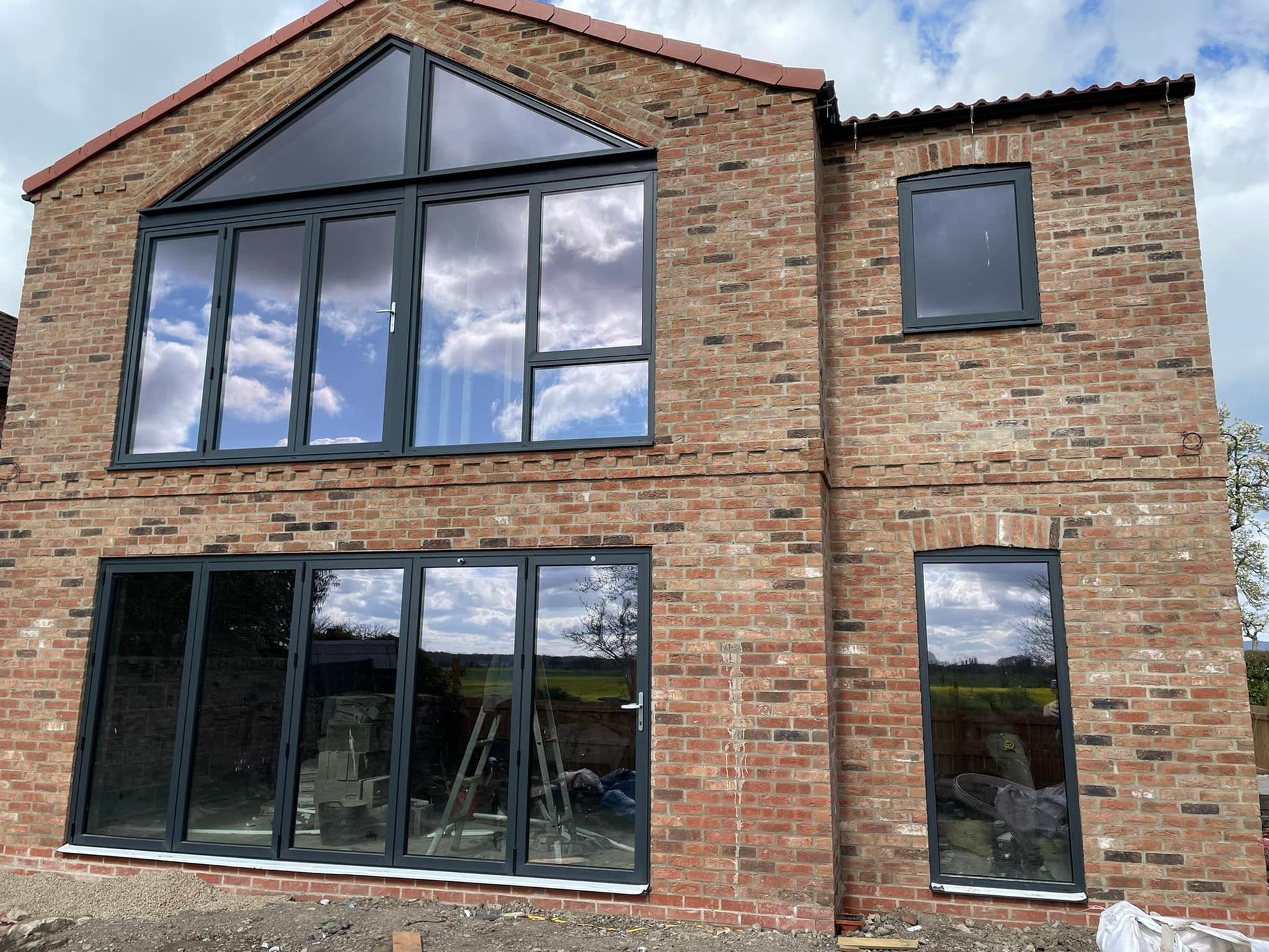A large brick house with a lot of windows and a red roof.