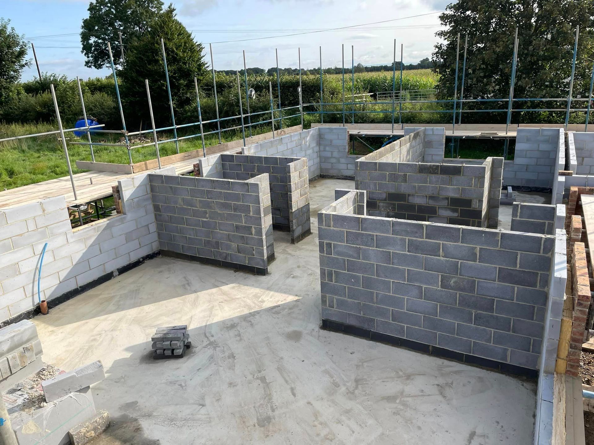 A building under construction with brick walls and scaffolding.