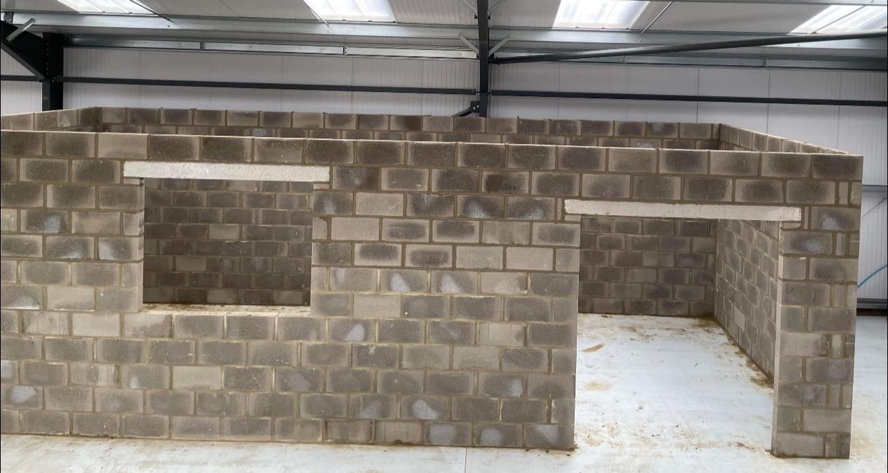 A brick wall is being built in a building.