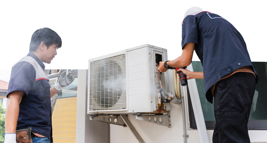 Two technicians in work uniforms service an outdoor air conditioning unit mounted on a wall.