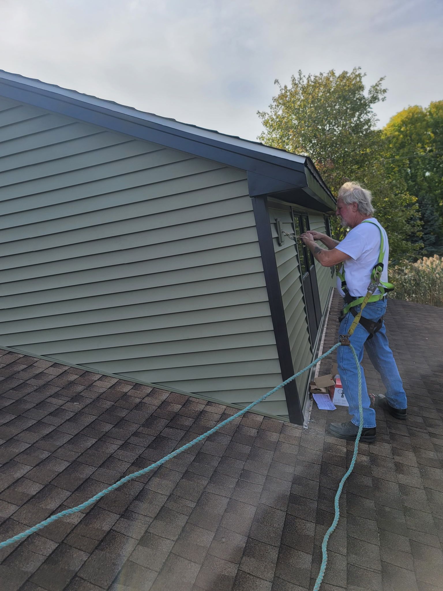 Man kneeling, removing wood flooring with a hammer and chisel.