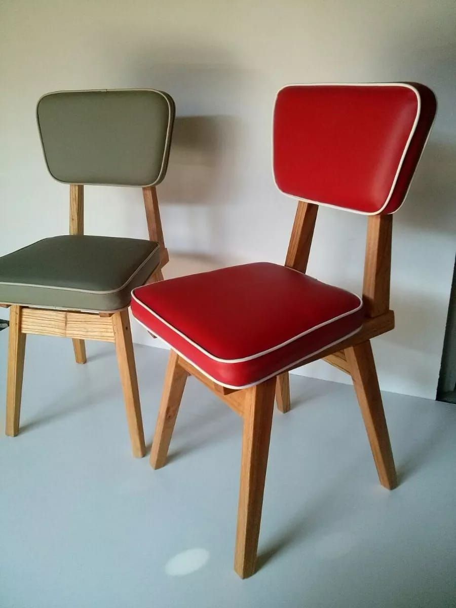 Dos sillas de estilo retro, una roja y otra verde, con detalles en blanco y patas de madera clara, sobre un fondo claro.