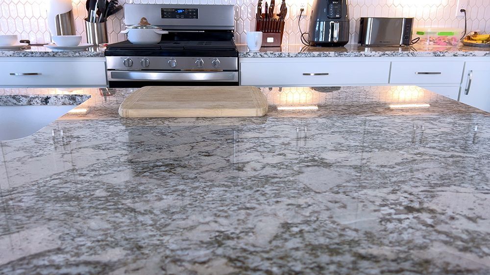 A kitchen with a granite counter top and a stove top oven.