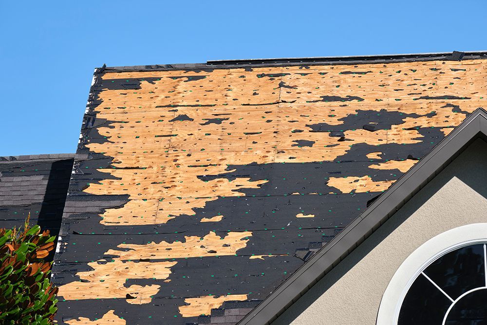 A house with a roof that has been damaged by a storm.