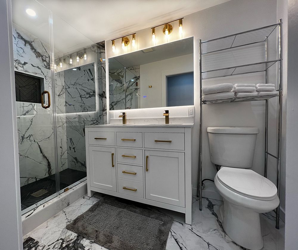 A bathroom with two sinks , a toilet , and a shower.