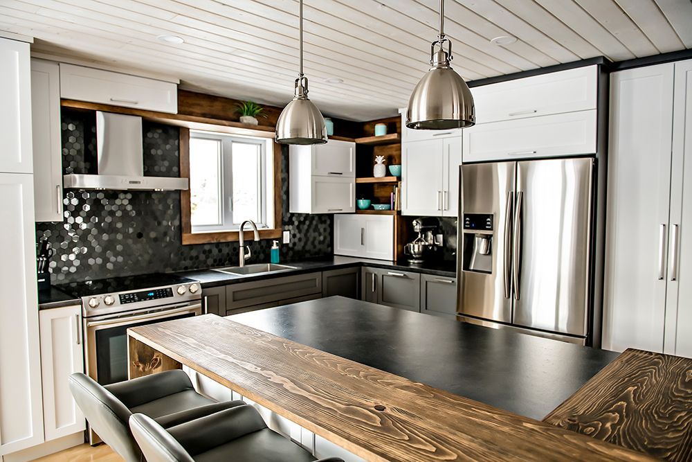 A kitchen with stainless steel appliances and a large wooden table.