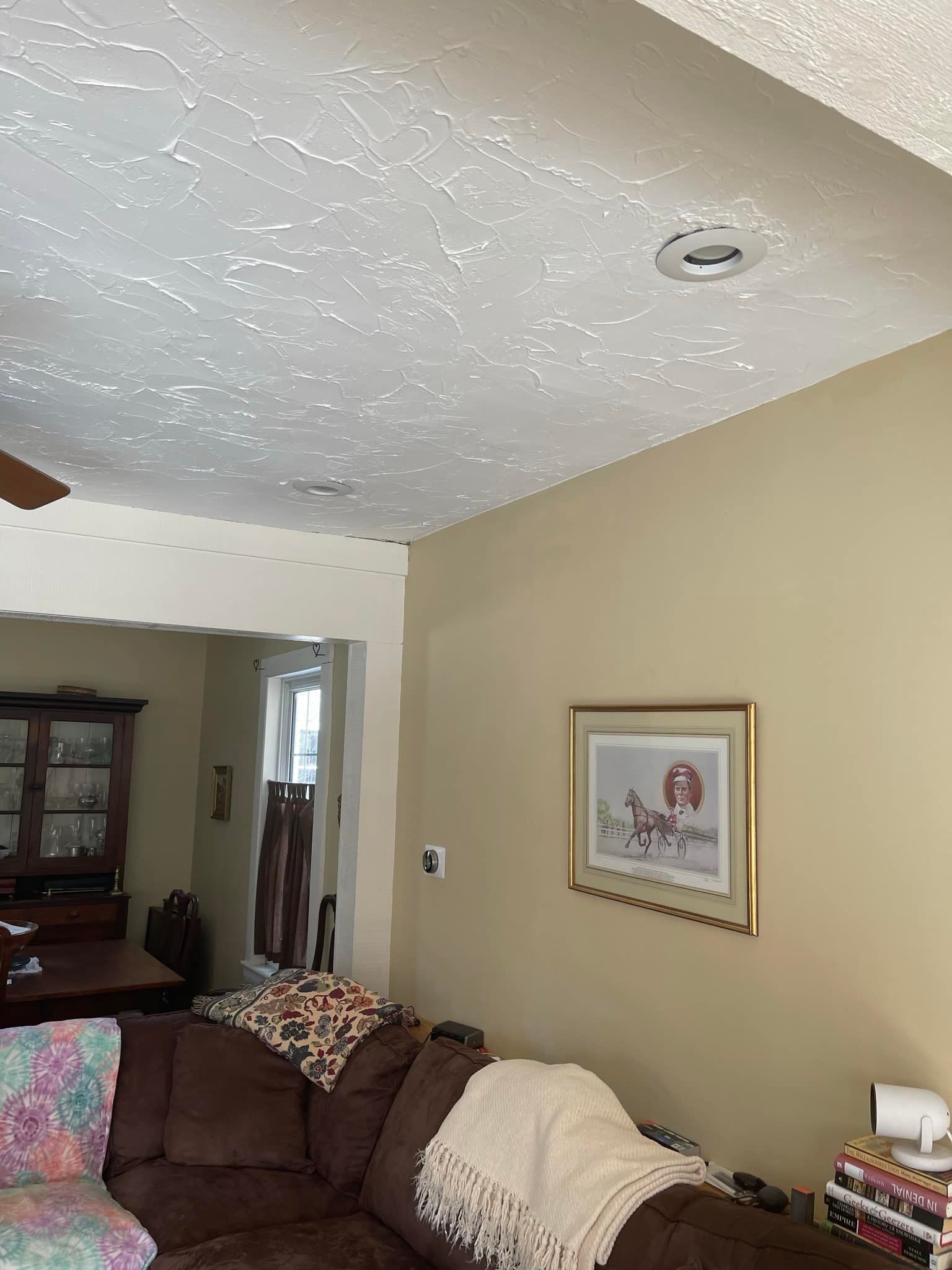 Living room with beige walls, textured ceiling, brown sectional, and artwork.