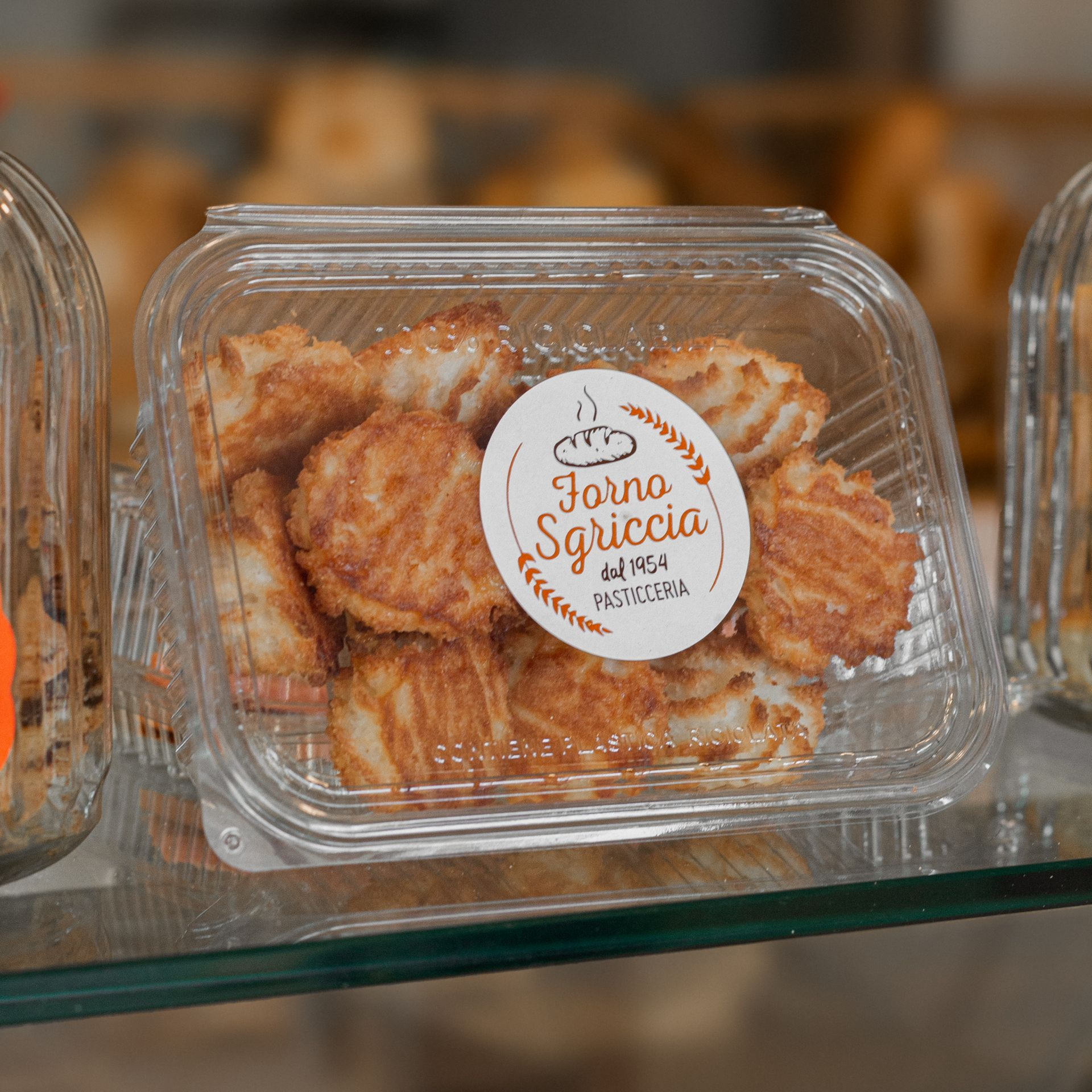 Un mucchio di palline di pasta fritte ricoperte di zucchero su un piatto bianco, probabilmente una pasticceria.