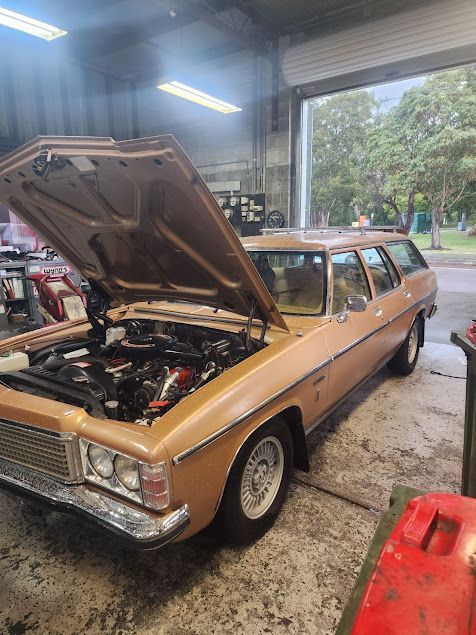 A Brown Car With The Hood Up Is Parked In A Garage — Airborne Auto Air in Wyong, NSW