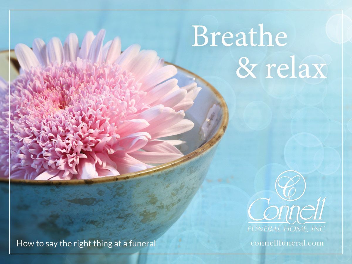 a pink flower in a bowl with the words breathe and relax