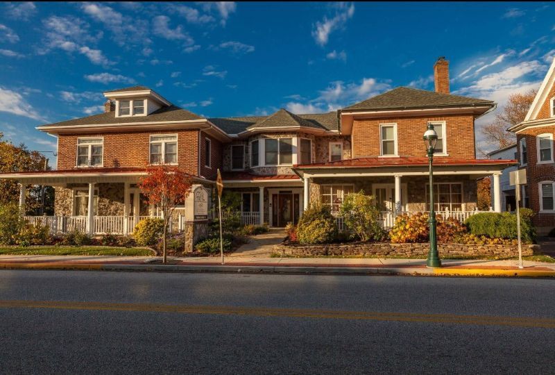 Beautiful exterior of a historic brick building with porch and garden at Nazareth, PA funeral home and cremations