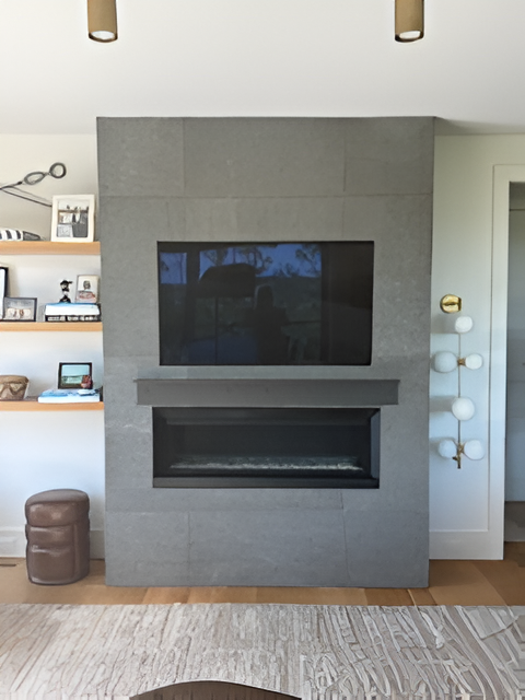 Gray tiled fireplace with mounted TV, shelf and modern light fixture.