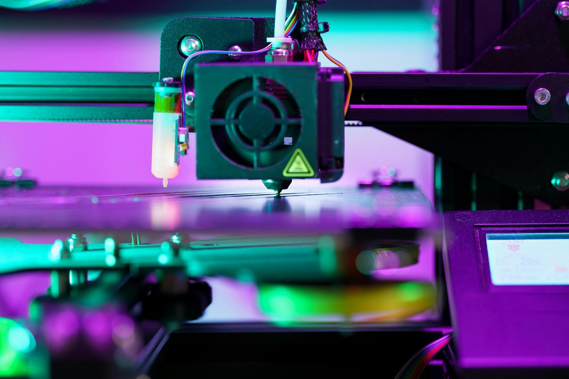 A close up of a 3d printer in a dark room.