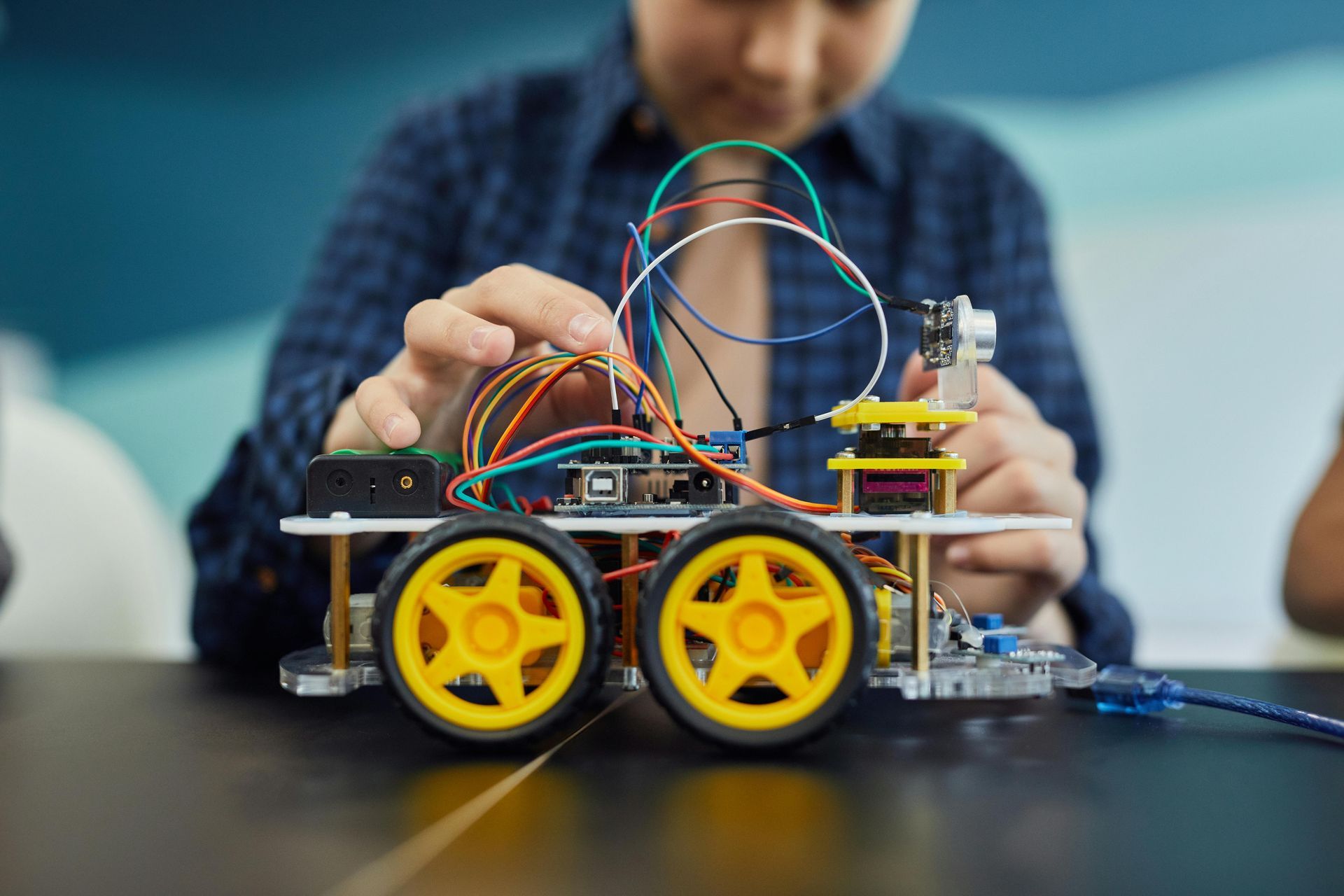 A person is working on a robot on a table.
