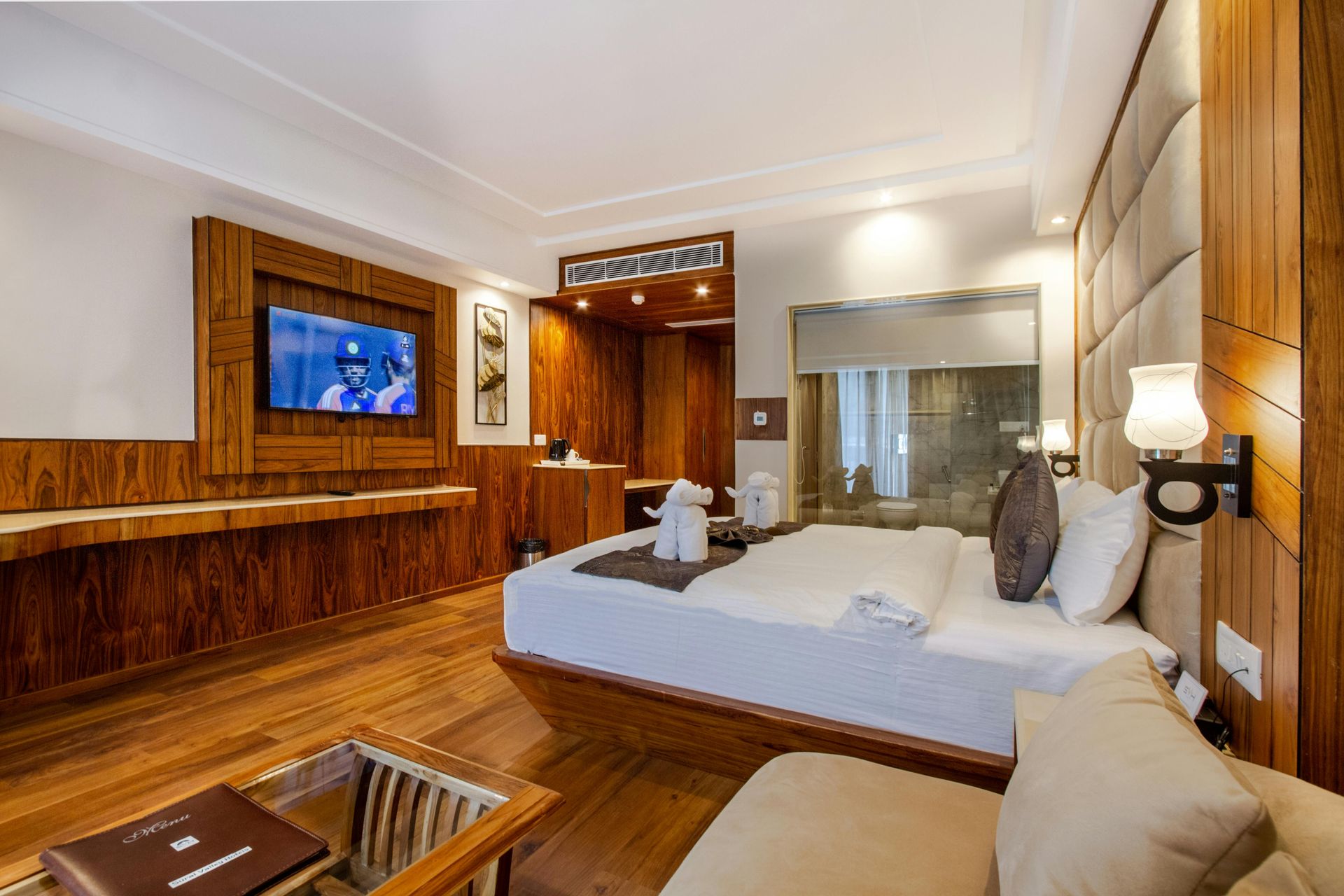 A hotel room with a large bed , couch , and television.