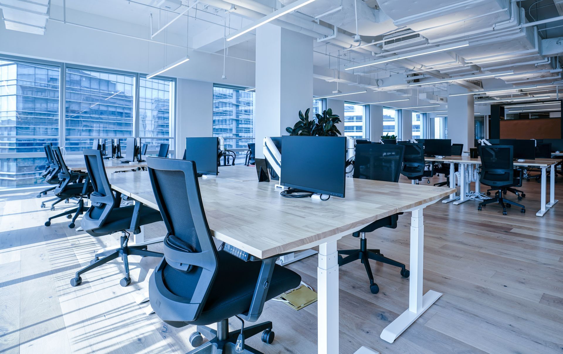 A large empty office with a lot of desks and chairs.