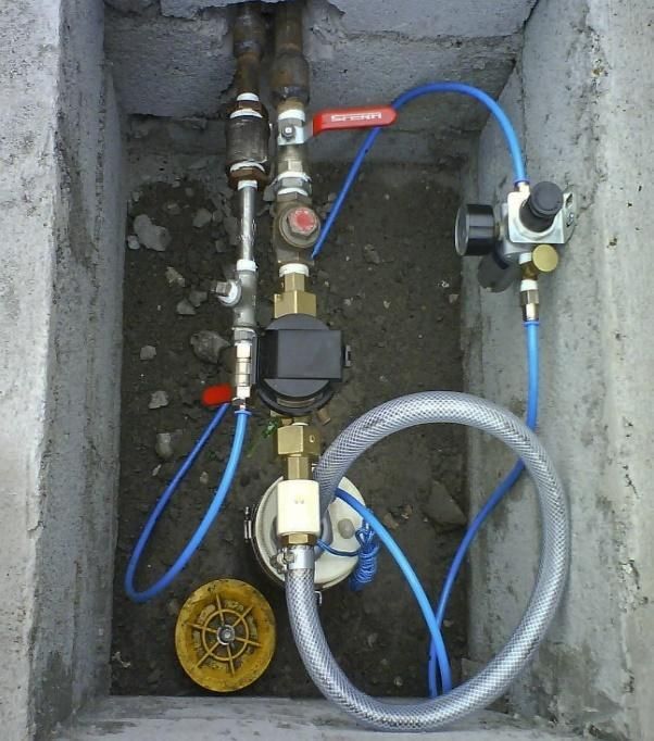 Um hidrômetro está conectado a uma mangueira em uma caixa de concreto