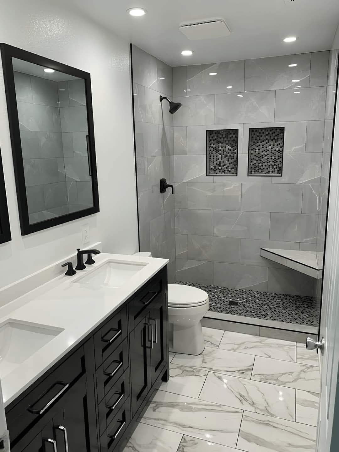 Une salle de bain avec lavabo, WC, douche et miroir.