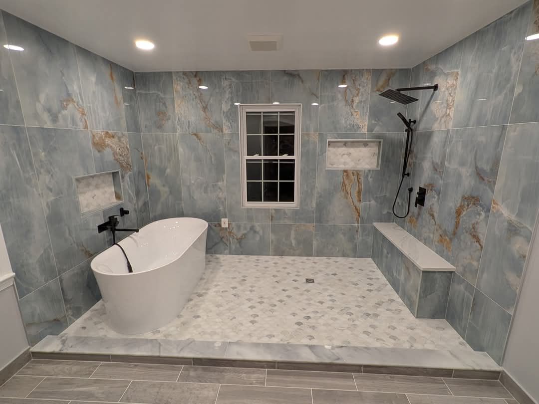 Une salle de bain avec baignoire, douche et fenêtre.