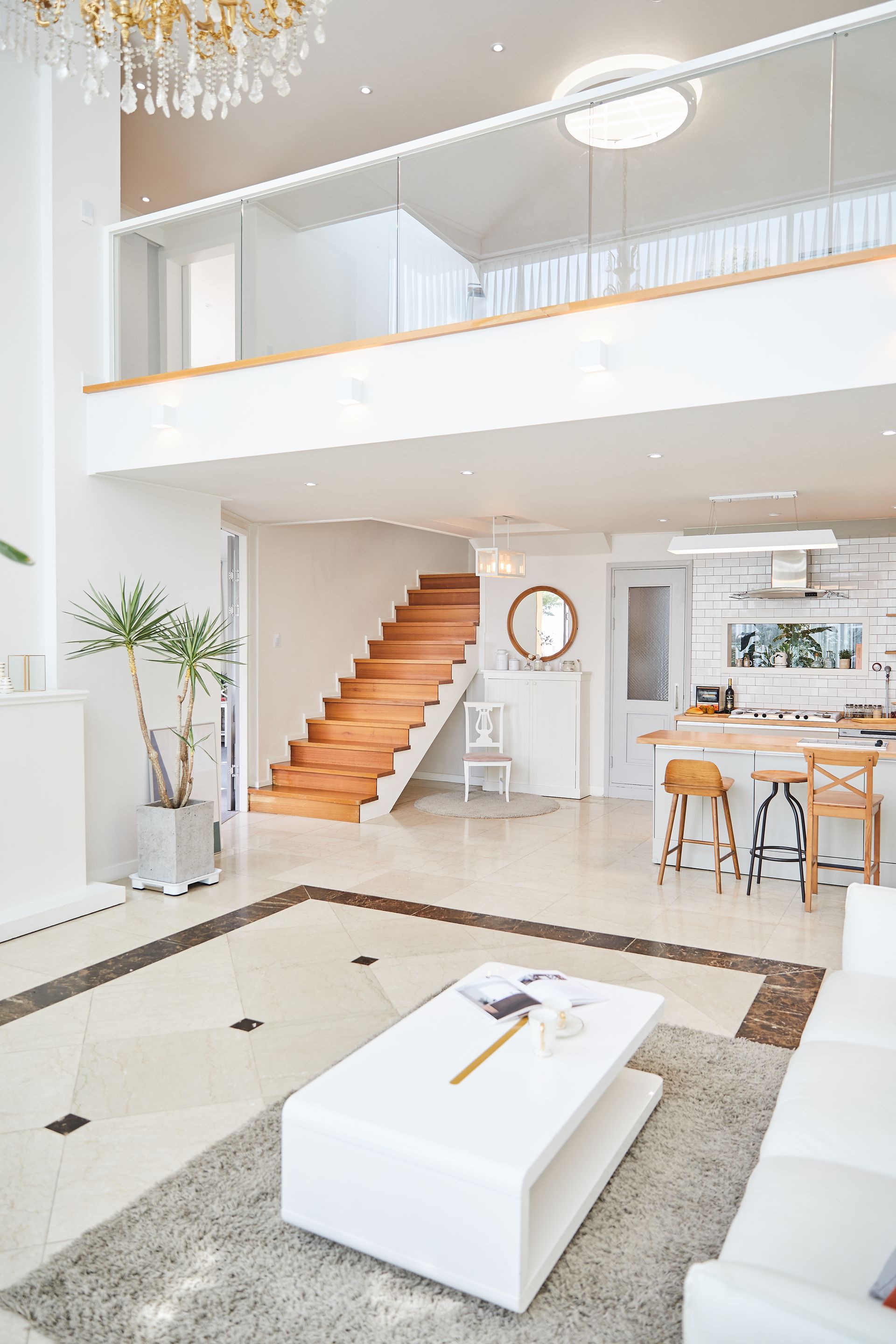 Un salon avec un canapé, une table et un escalier.