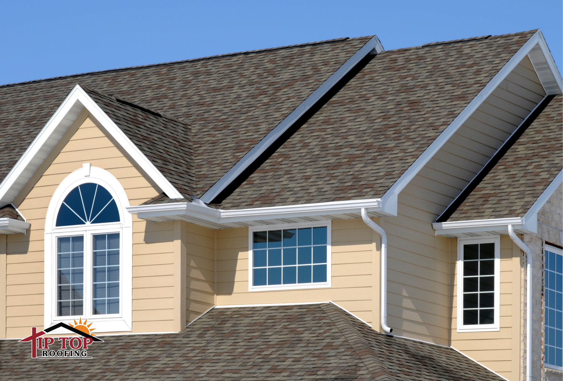Residential home with asphalt shingle roof under bright summer sun