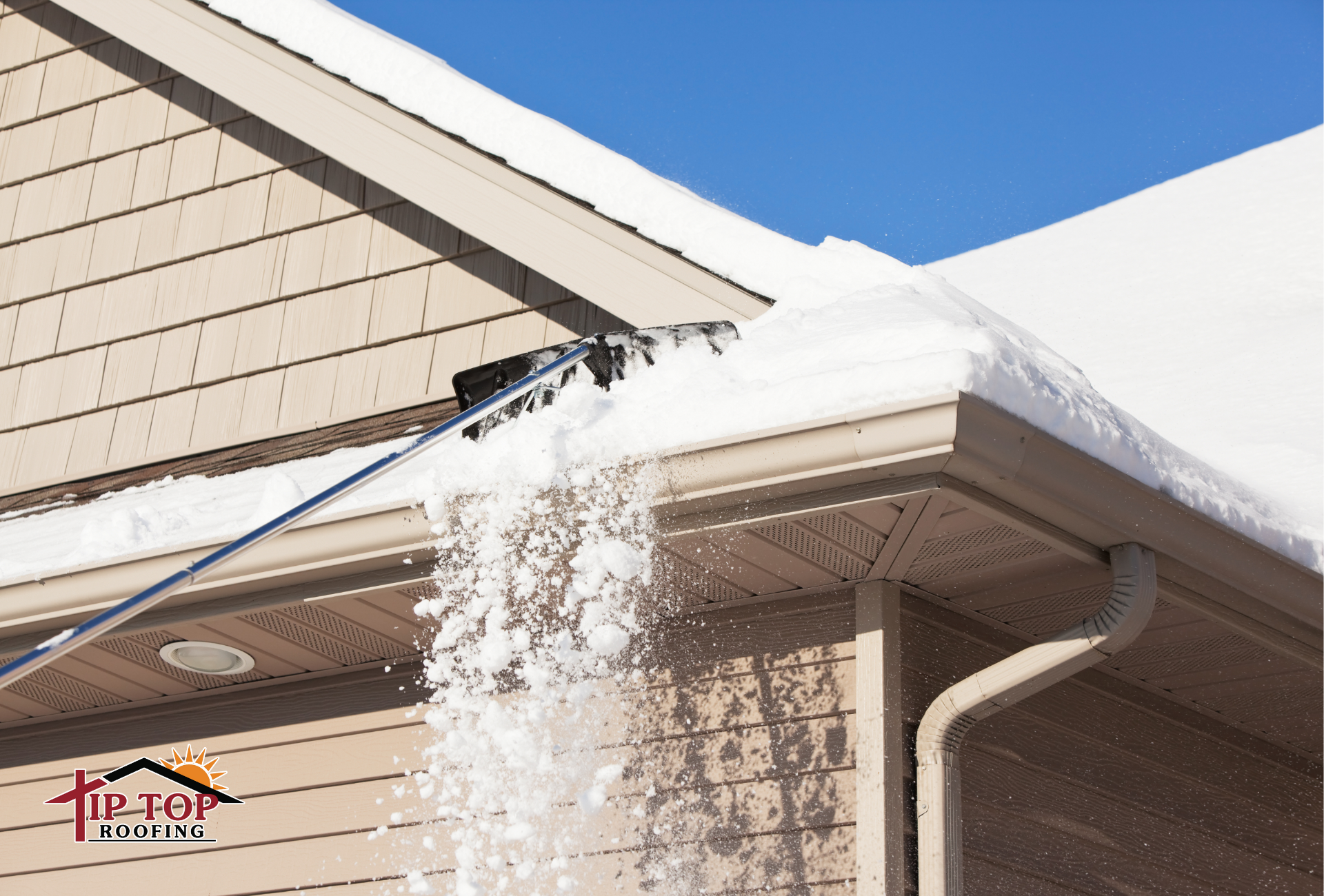 Snow is being removed from a shingle roof using a roof rake