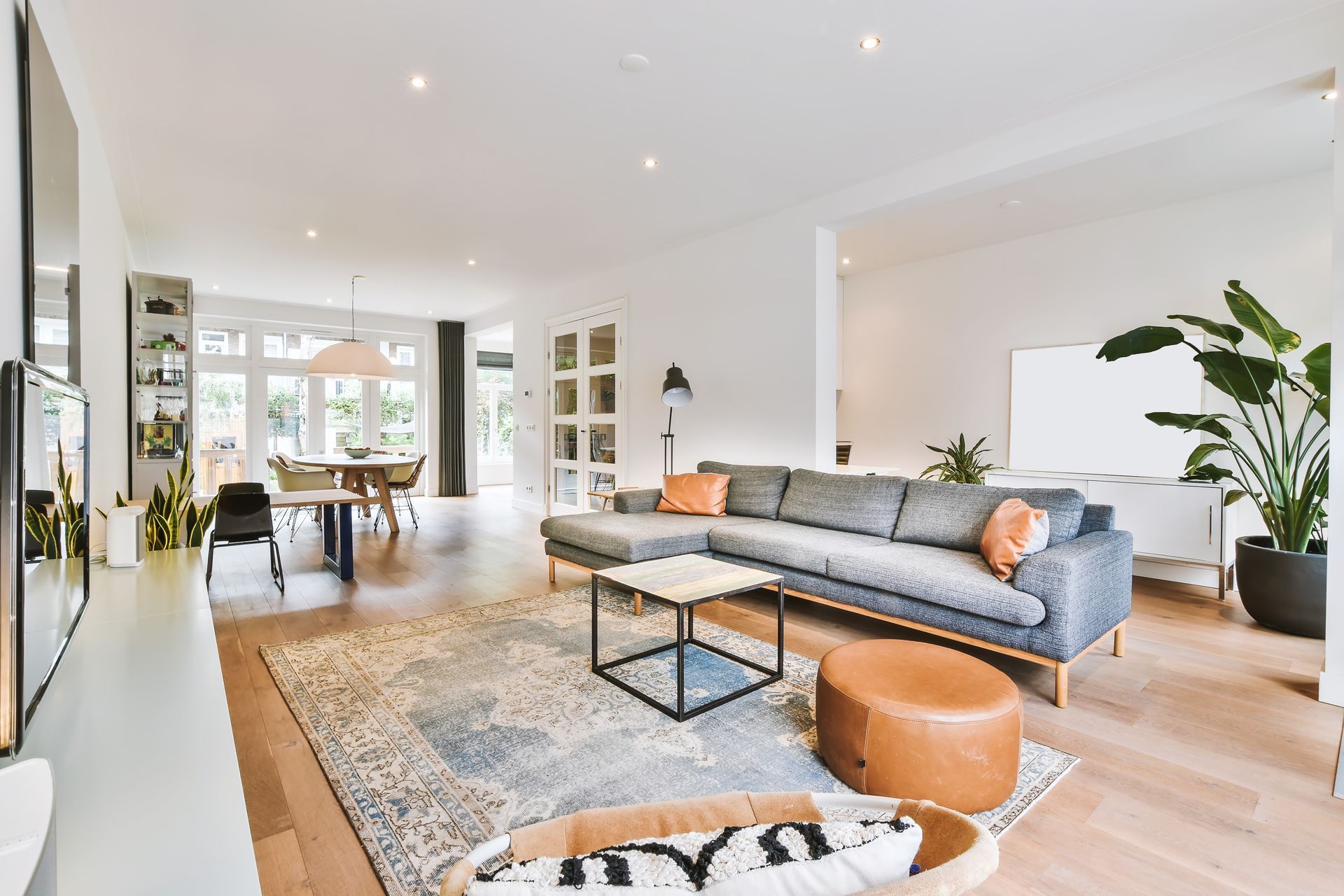Un salon avec un canapé, une table basse et un pouf.