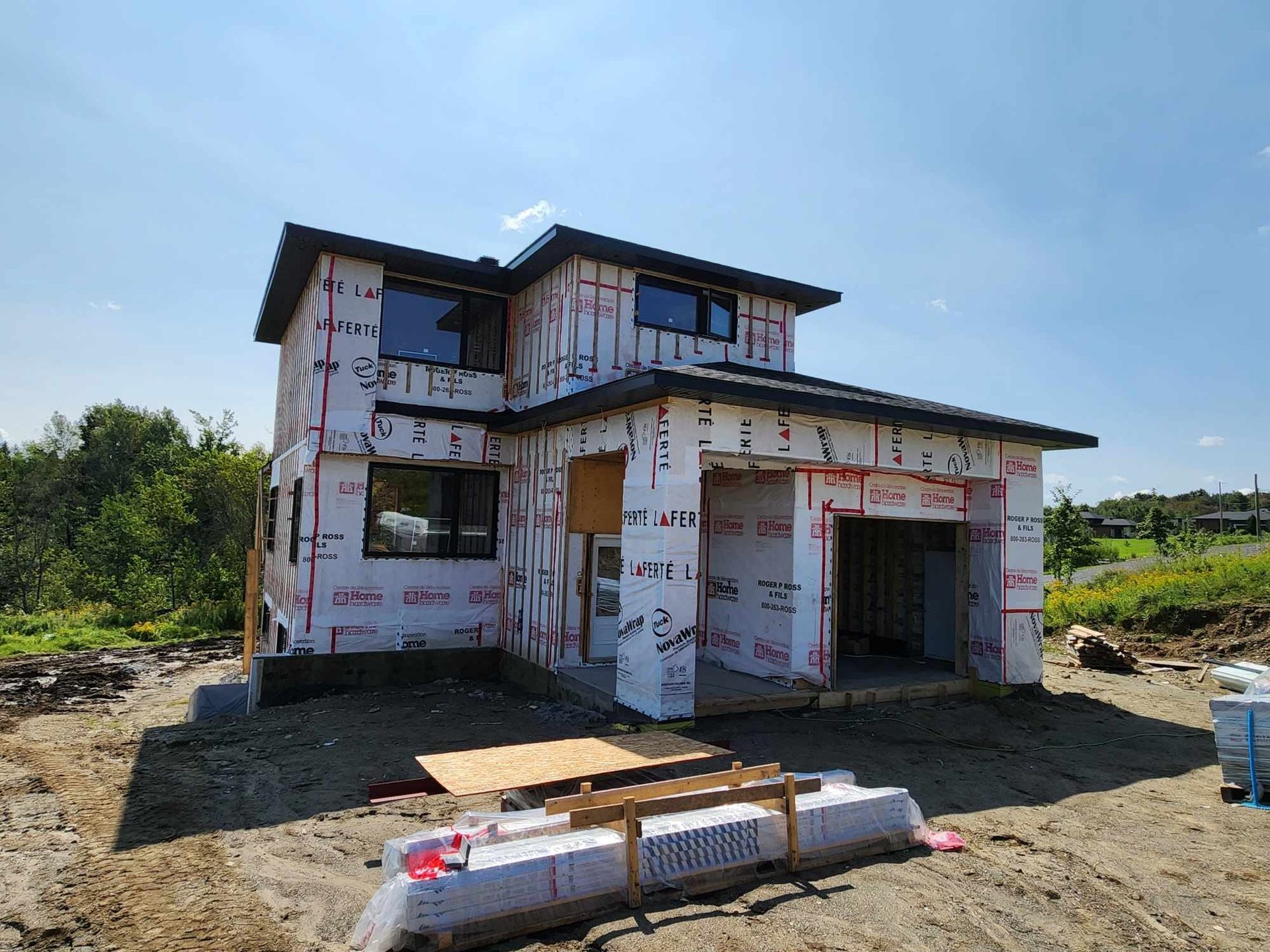Une maison est en construction au milieu d'un champ de terre.