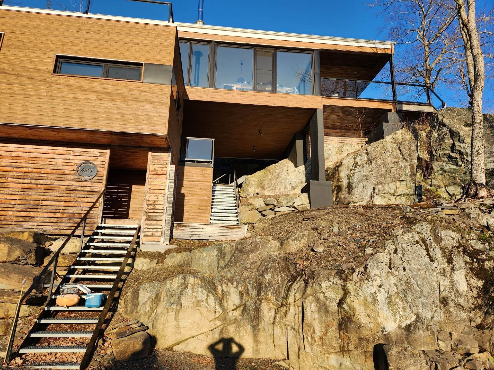 Une maison est située au sommet d'une colline rocheuse avec des escaliers qui y mènent.