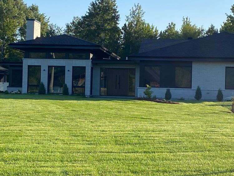 Une maison avec une grande pelouse devant elle