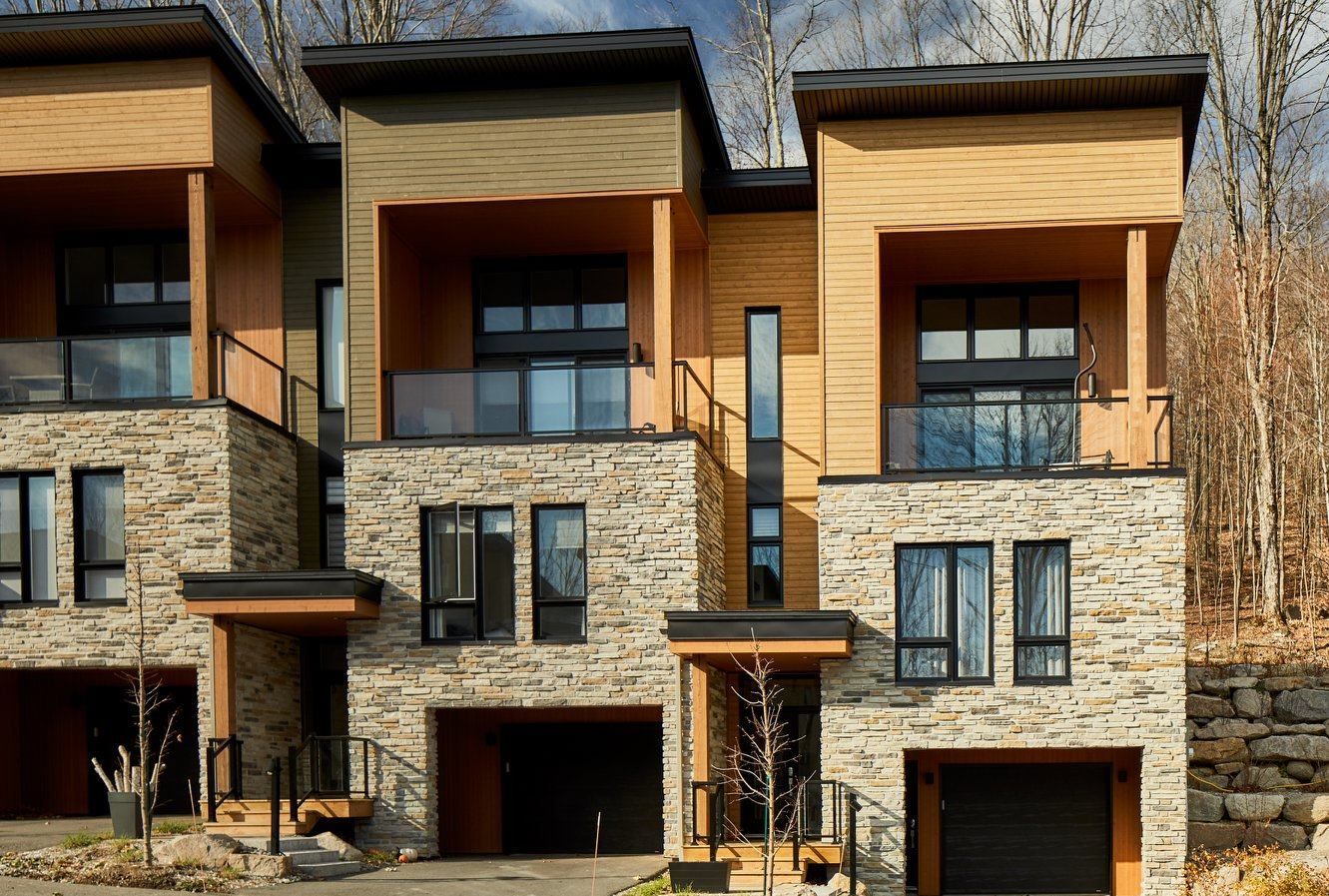 Une maison moderne avec beaucoup de fenêtres et un garage.