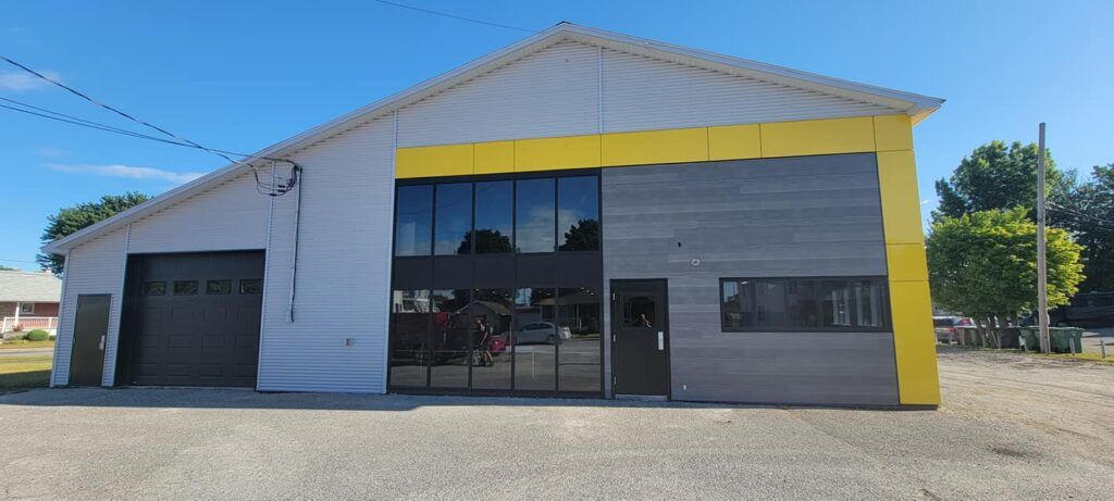 Un grand bâtiment blanc avec une bordure jaune et une porte de garage.
