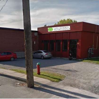 Un bâtiment rouge avec une voiture garée devant.