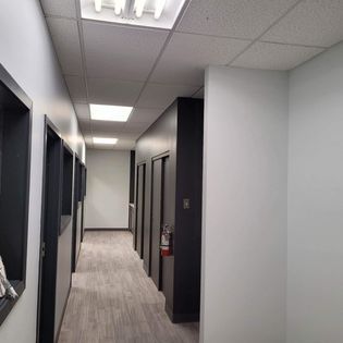 Un long couloir dans un bâtiment avec un extincteur sur le mur.