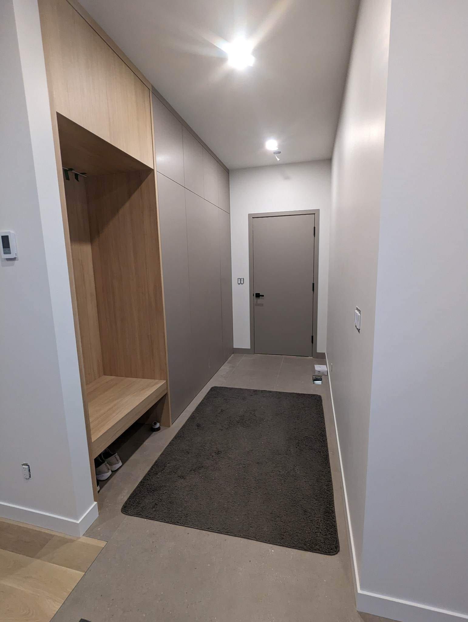 Un couloir avec un tapis et une porte dans une maison.