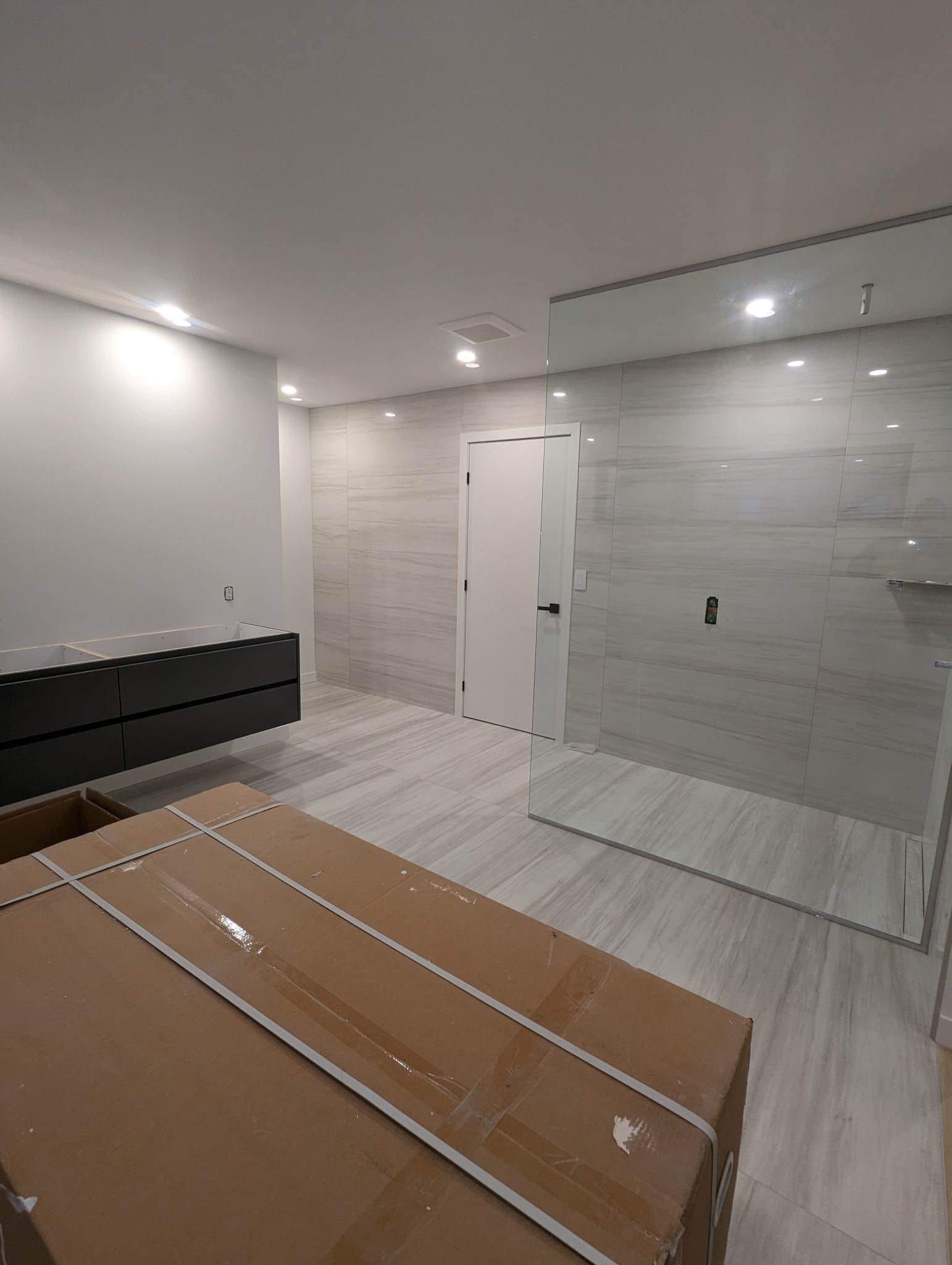 Une salle de bain avec une douche à l'italienne et un grand miroir.