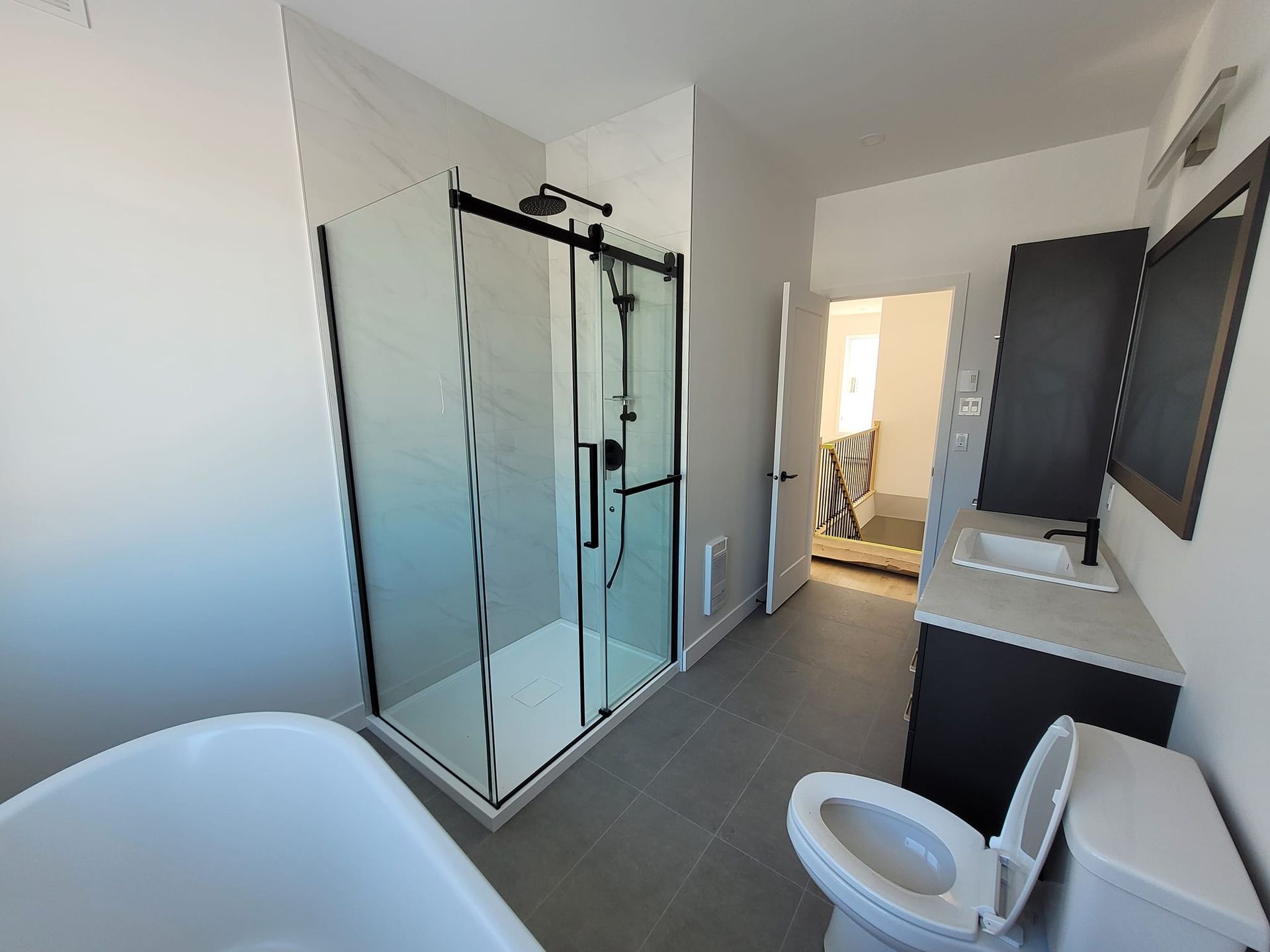Une salle de bain avec WC, lavabo, douche et baignoire.