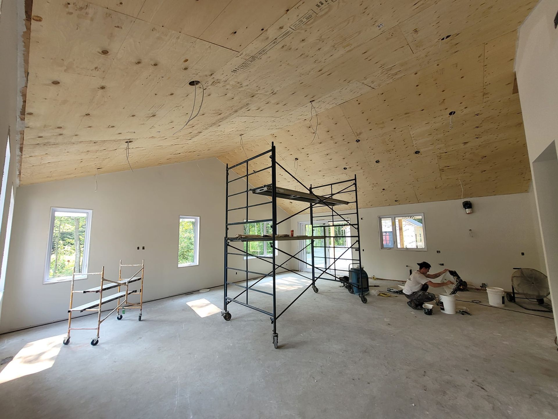Une grande pièce avec un plafond en bois et des échafaudages