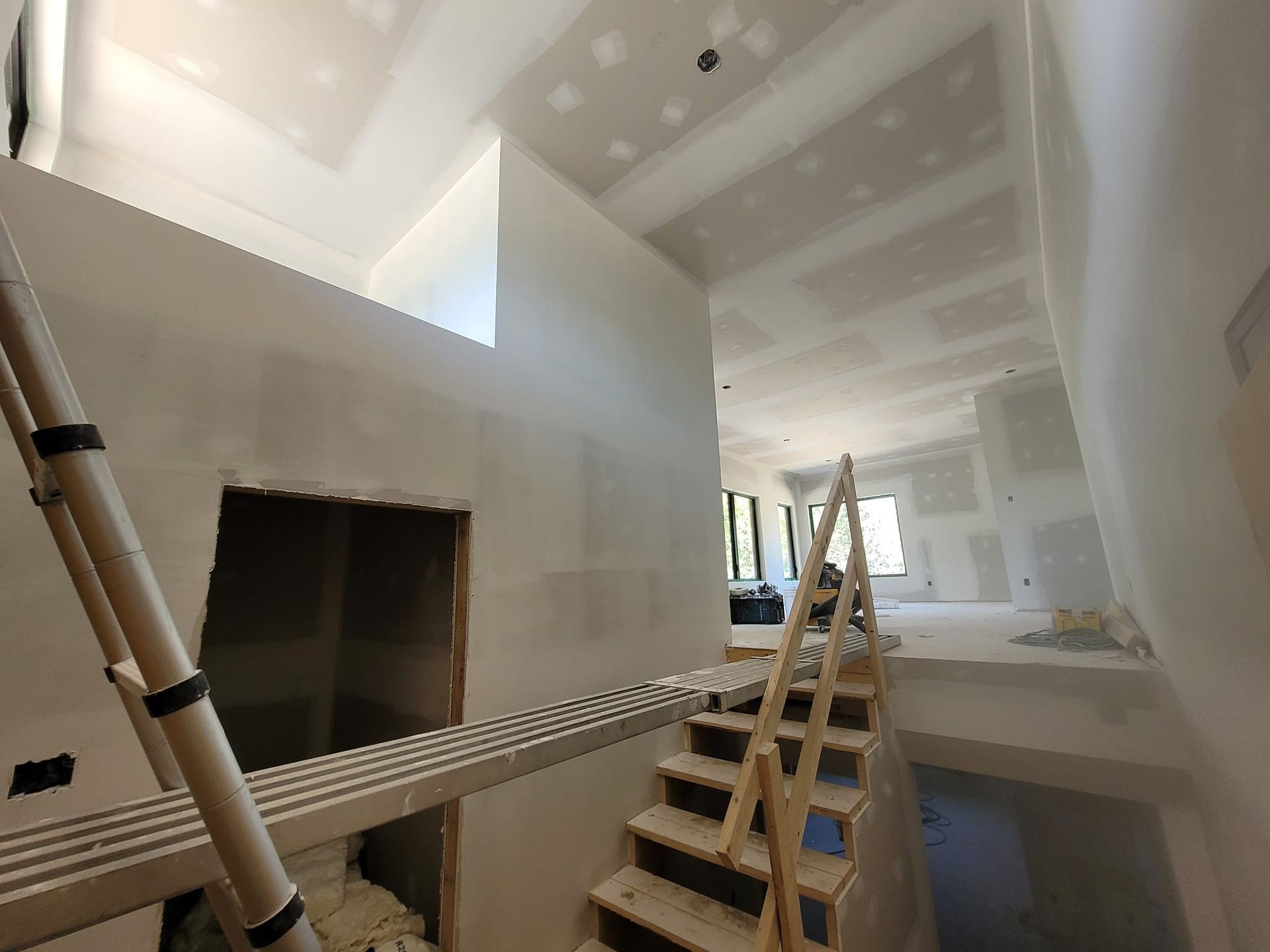 Une échelle est posée au milieu d'une pièce à côté d'un escalier.